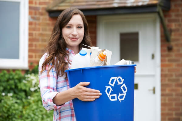 women holding full recycling bin